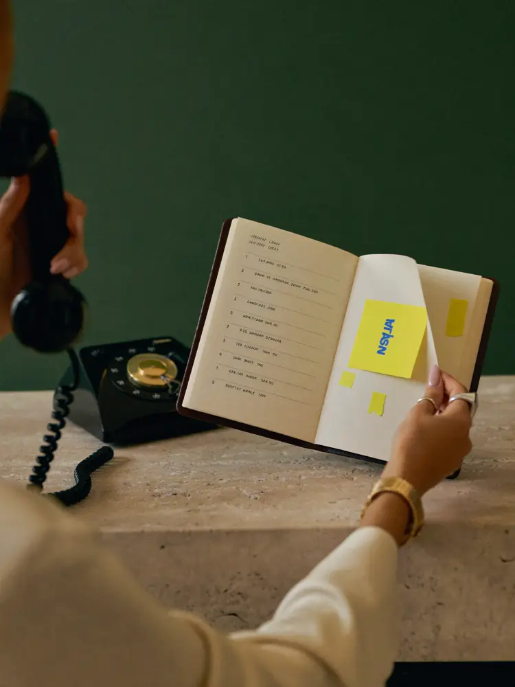 Escritorio de secretaría entre planillas, teléfono y cuaderno